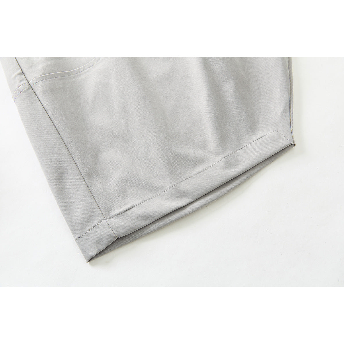 Close-up of the light gray pants' leg and stitched hem.
