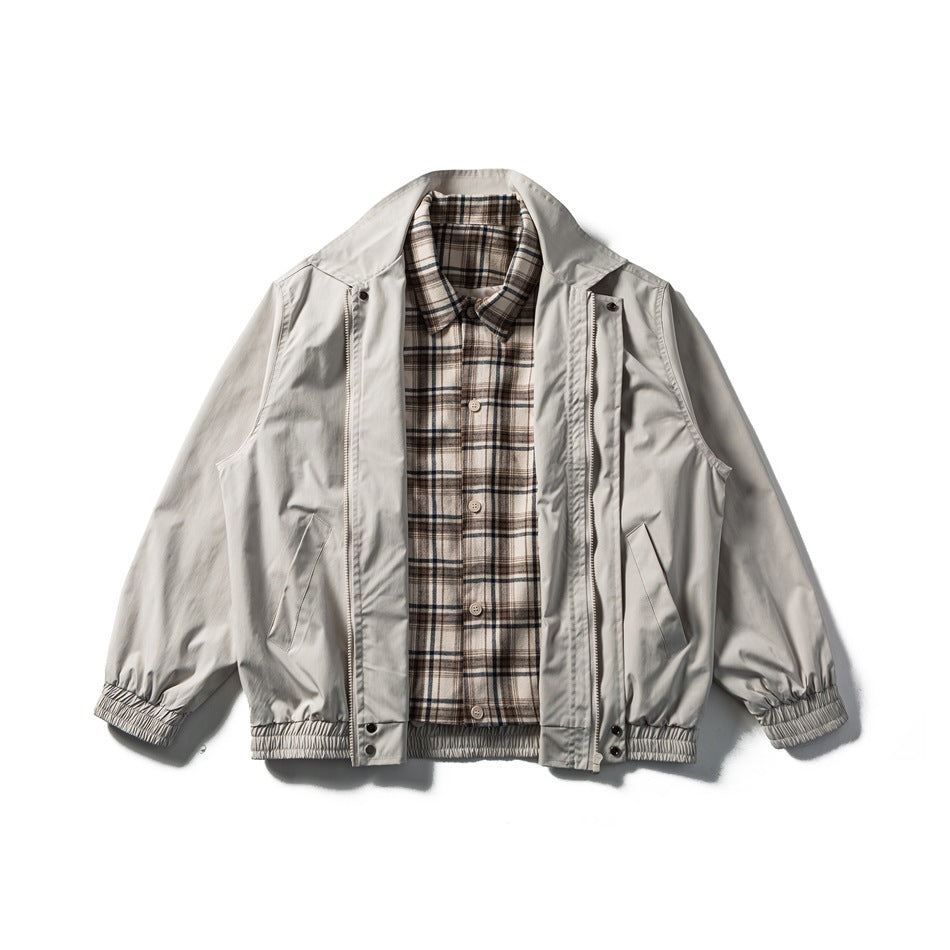 Beige-apricot jacket flat lay with the zip front open, showing the plaid button-up shirt layer underneath