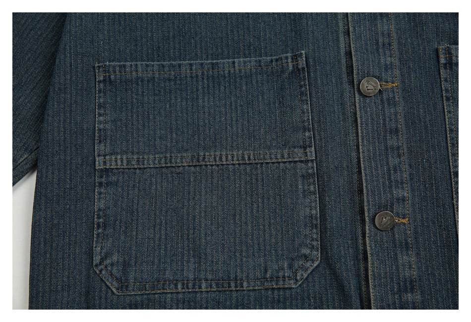 Close-up of a large patch pocket and metal buttons on the dark blue denim jacket.