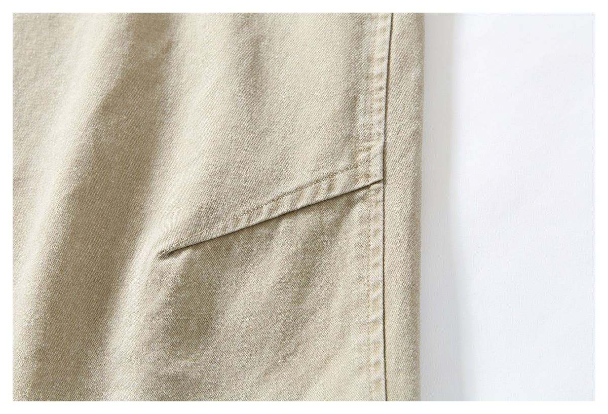 Close-up of beige pants showing a diagonal side pocket opening and stitched seams.
