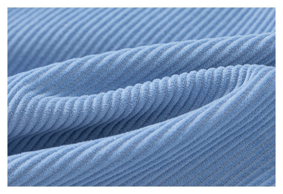 Macro view of the raised ribs and texture of light blue corduroy fabric.