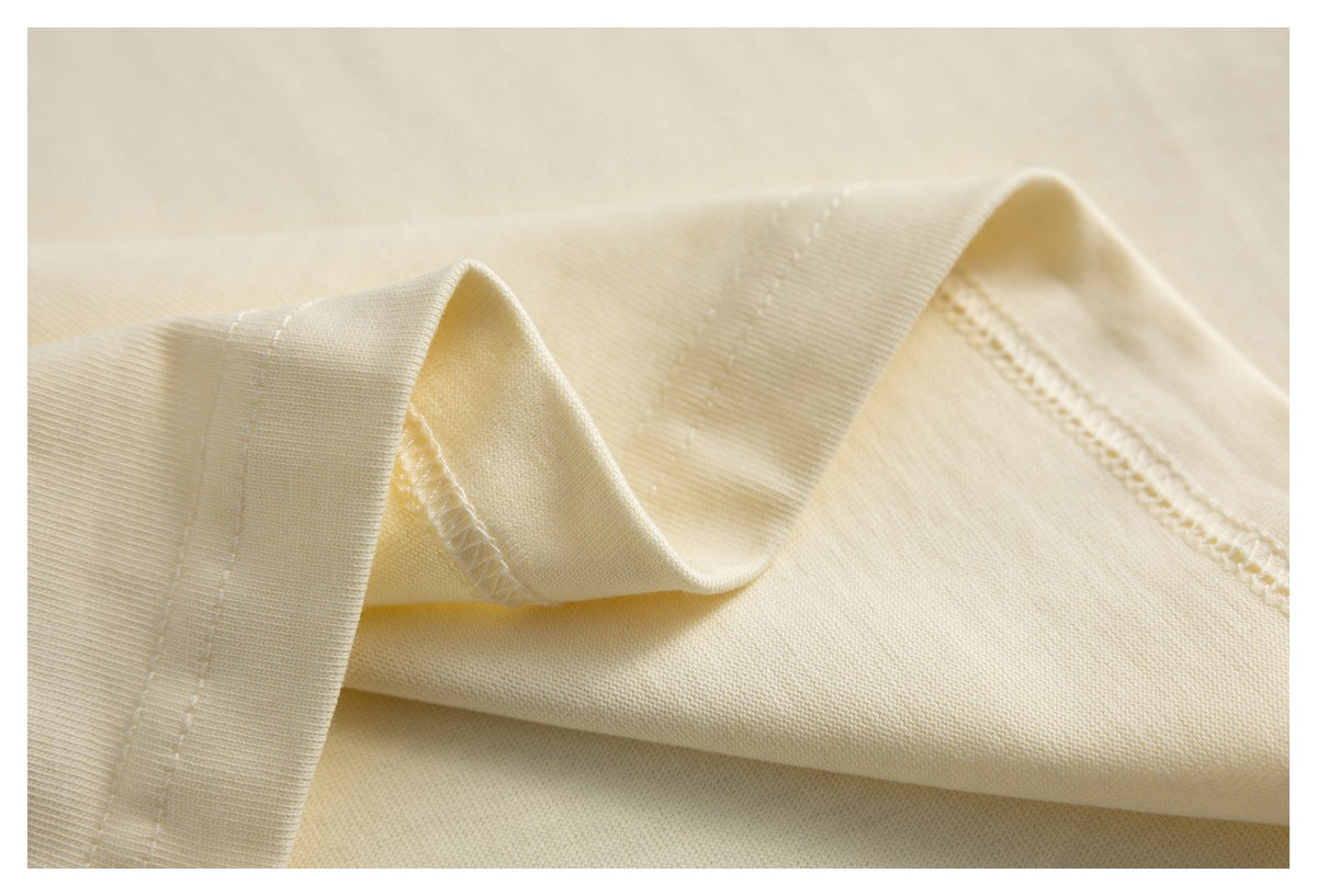 Close-up of cream fabric showing a folded hem and stitching.