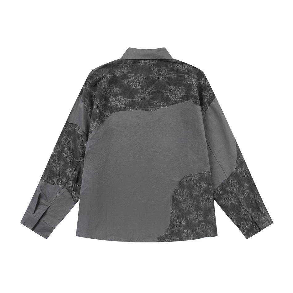 Back of a charcoal gray long-sleeve button-up shirt with irregular black textured panels on a white background.