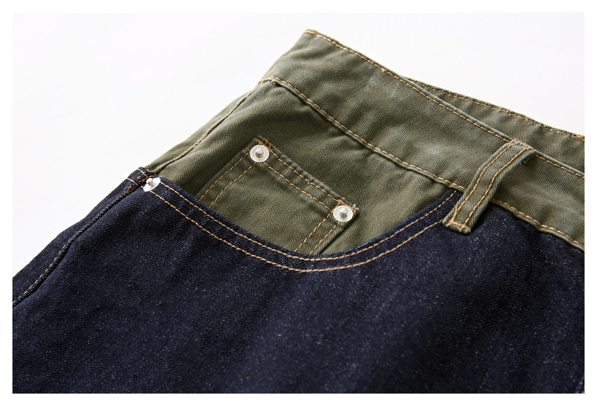 Close-up of the olive-green waistband and small riveted pocket above dark indigo denim shorts.