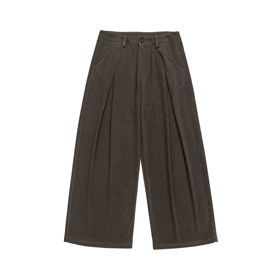 Front view of brown wide-leg trousers with front pleats, slanted pockets, belt loops and a button closure.