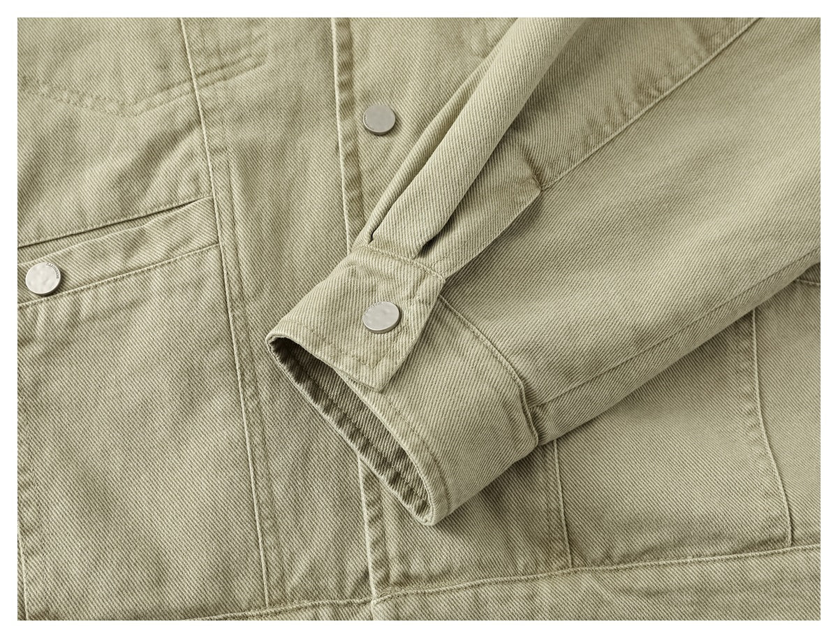 Close-up of a khaki jacket sleeve cuff with a silver snap, alongside the front pocket and seams.