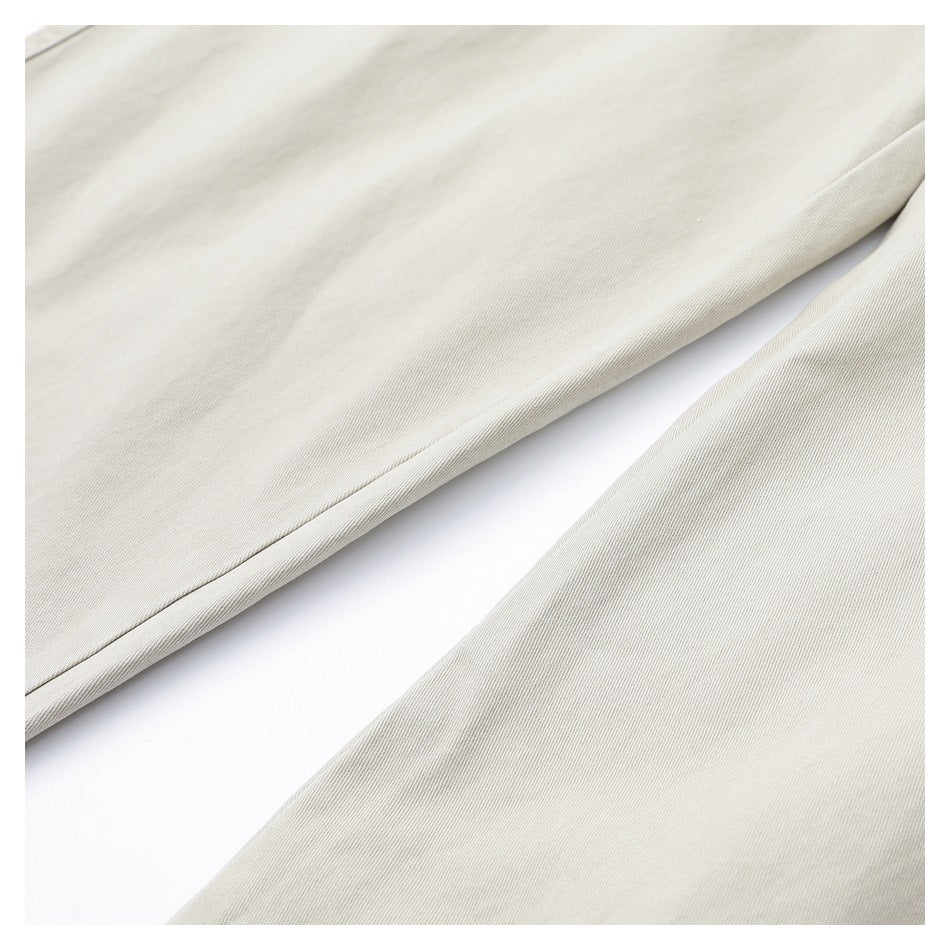 Close-up of light beige fabric draped in soft folds, showing its fine diagonal weave.