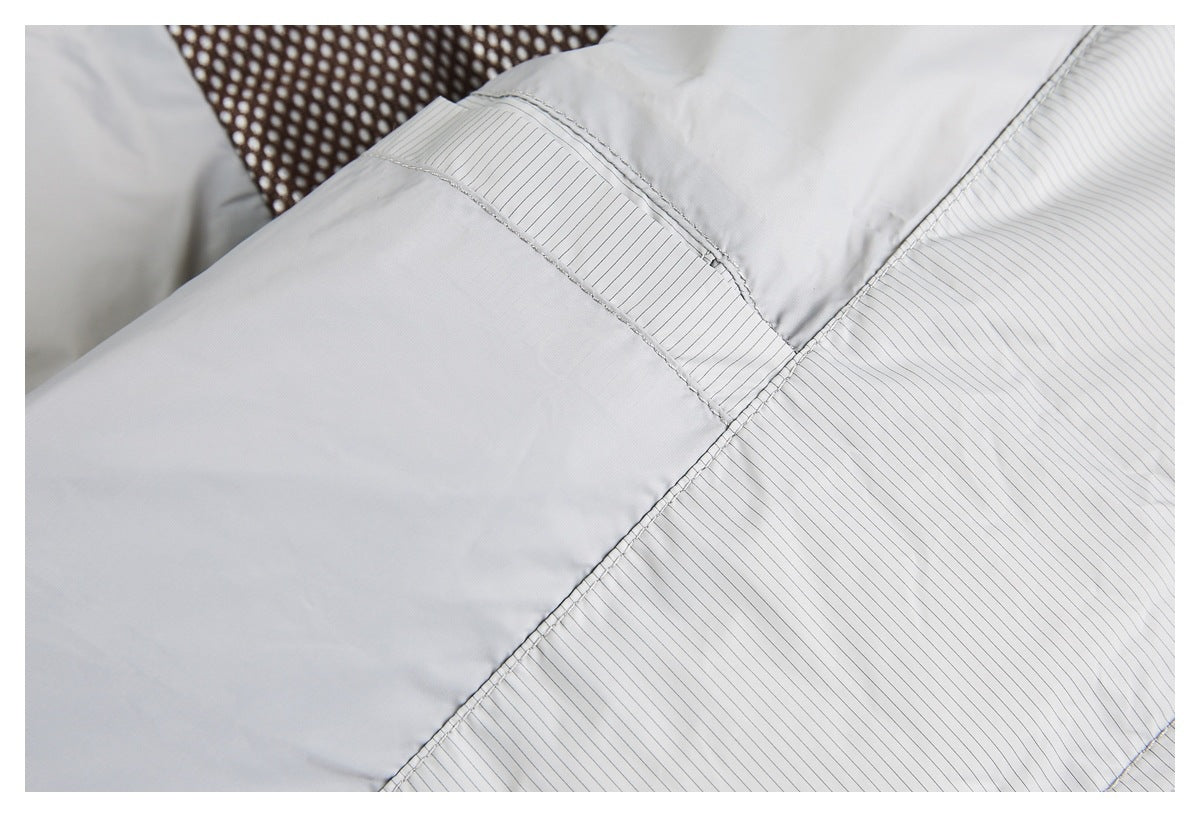 Close-up of light gray pinstriped and plain panels joined by visible stitching.