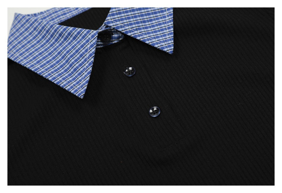 Close-up of the black ribbed front, dark buttons, and blue plaid collar of a top.