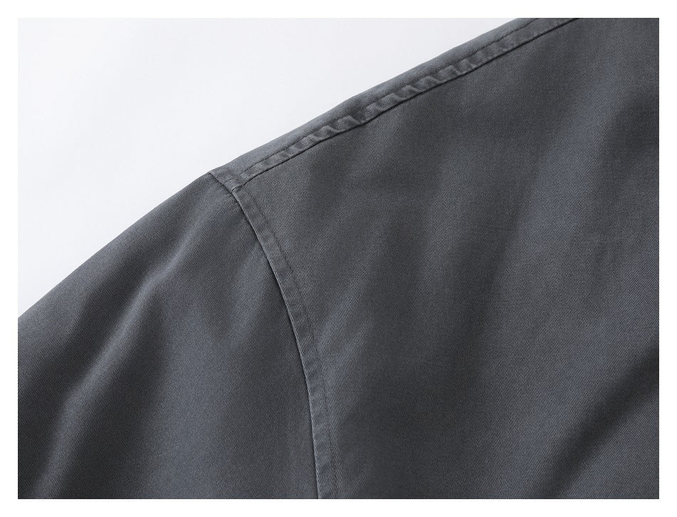 Close-up of a charcoal jacket shoulder seam and textured fabric surface.