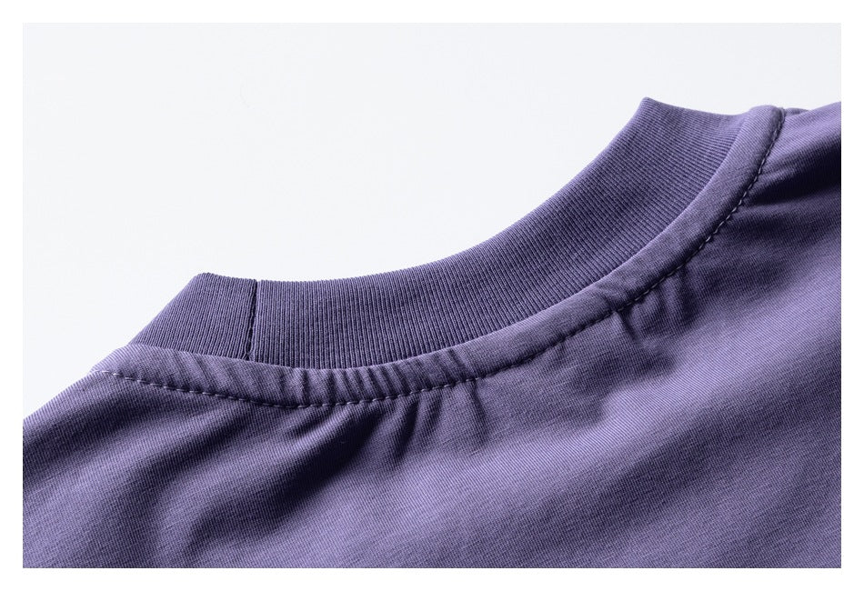 Close-up of a lavender-purple shirt's ribbed crew neckline and stitched collar seam.