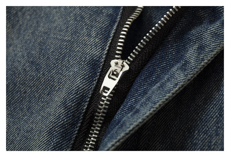 Close-up of a silver metal zipper and dark zipper tape on blue denim.