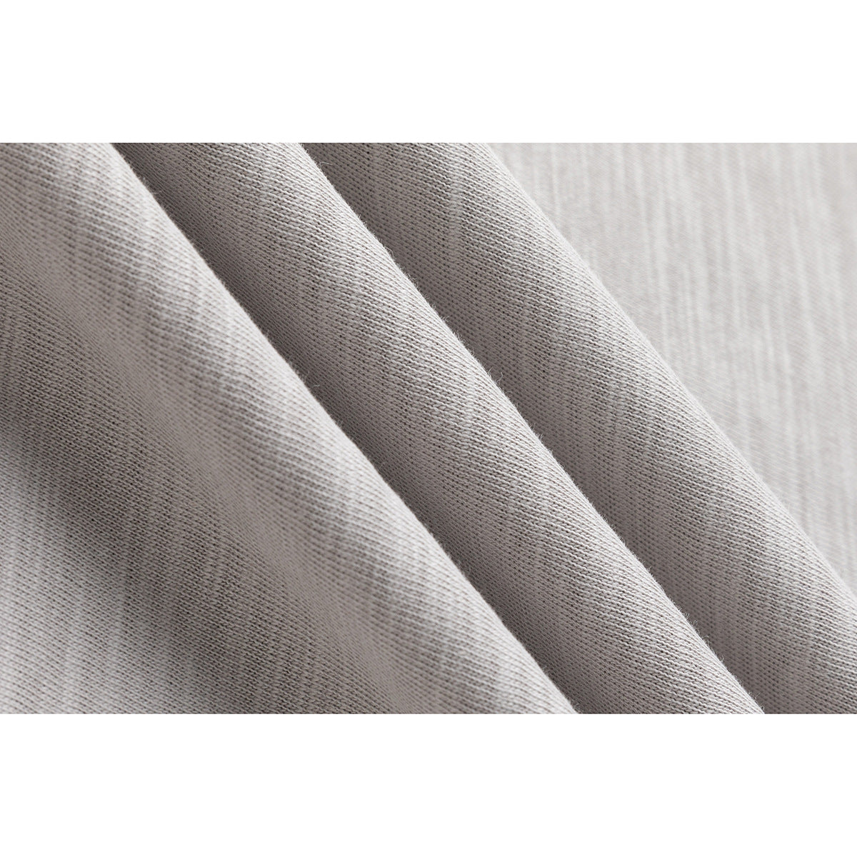 Macro view of light gray heather knit fabric draped in soft folds.
