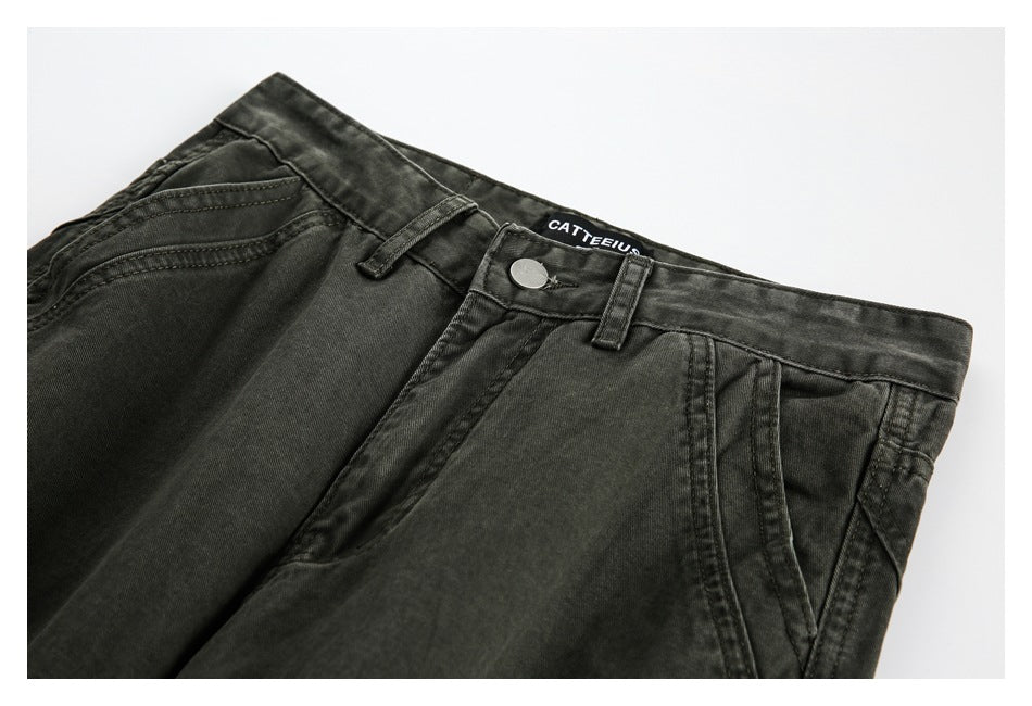 Close-up of charcoal trousers showing the waistband, belt loops, front pockets, button and sewn label.