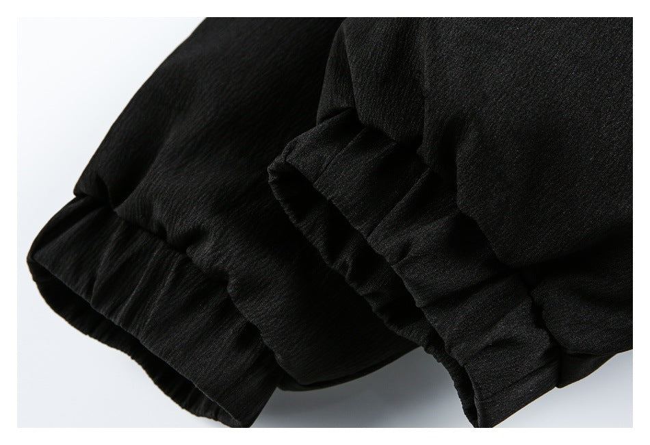 Close-up of a black garment edge with gathered elastic and layered fabric.