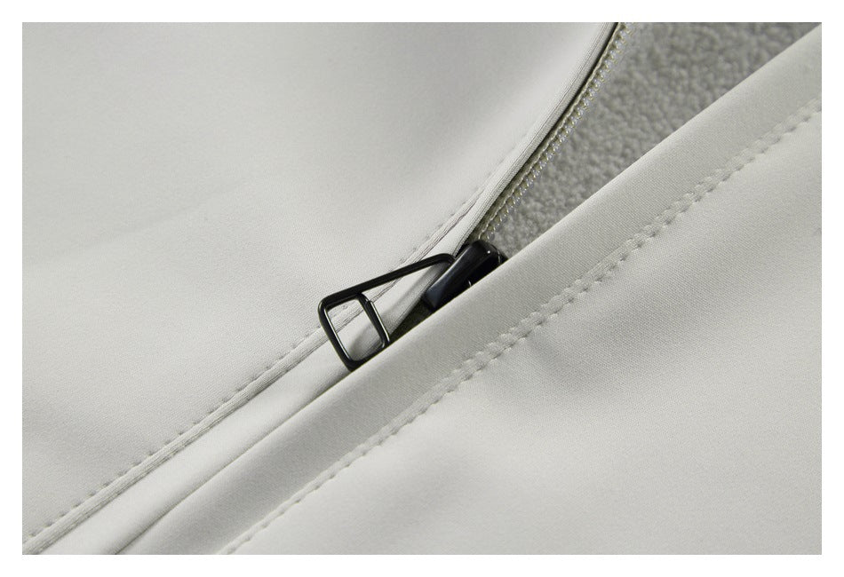 Close-up of a black zipper and stitched placket on light gray fabric, with textured lining visible.