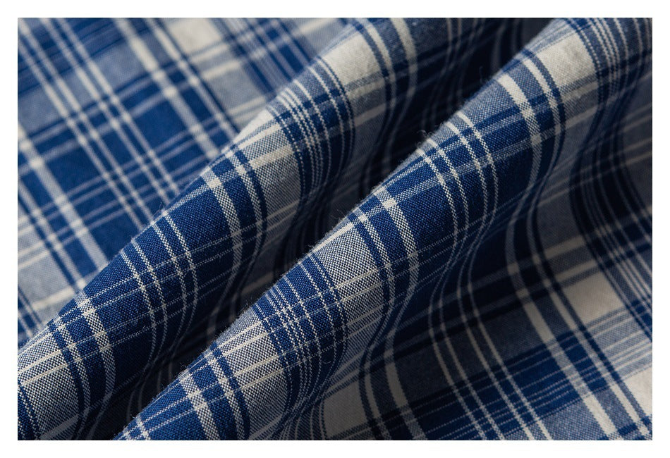 Close-up showing the woven texture and folds of blue, white, and gray plaid fabric.