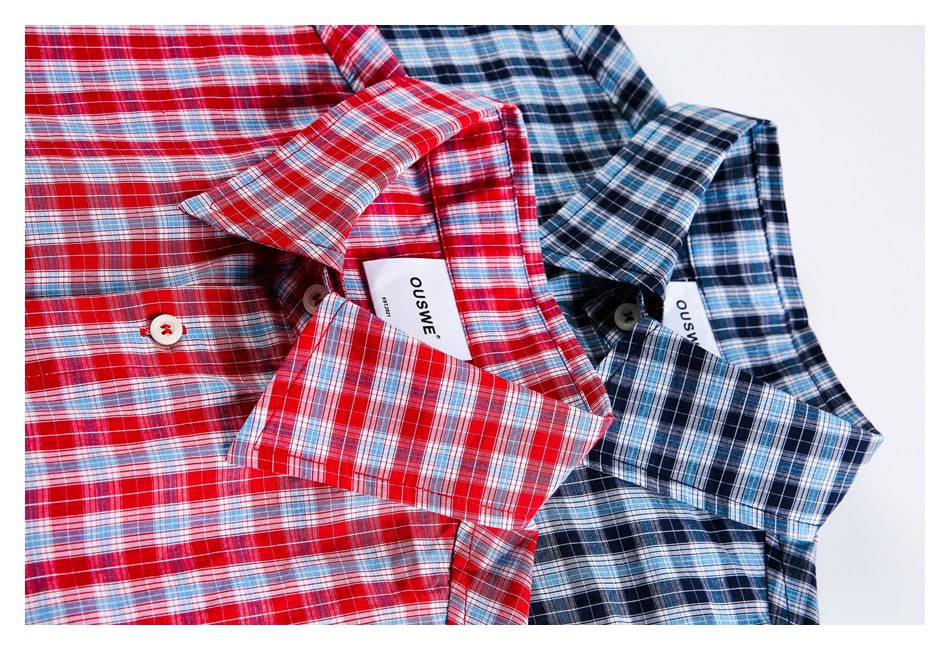 Close-up of the collars and cuffs of red and blue plaid button-up shirts.