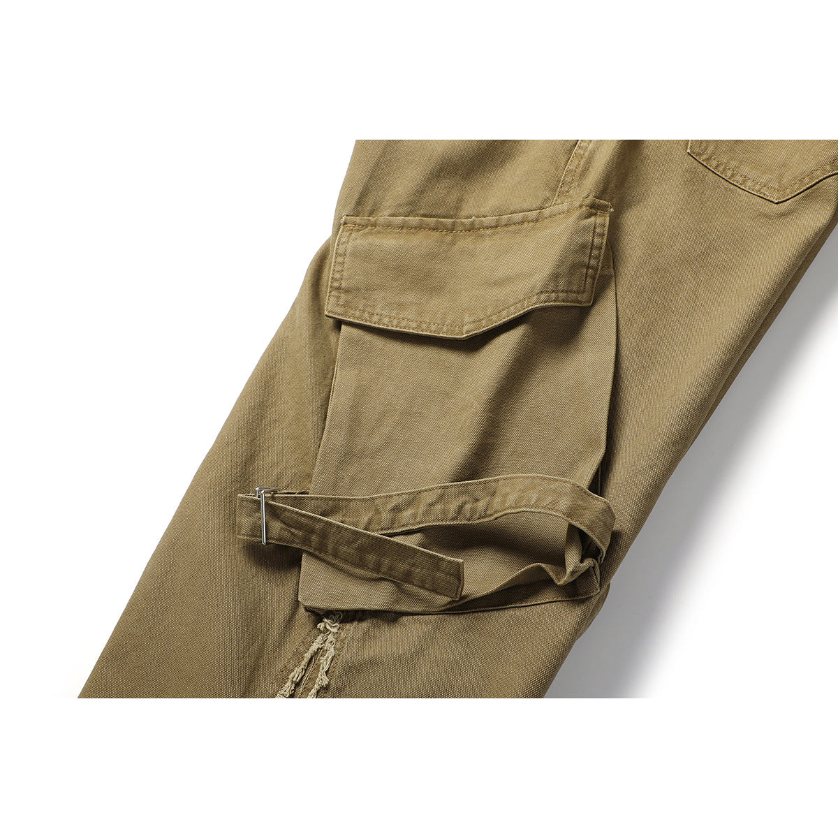 Close-up of tan cargo pants showing a flap pocket, adjustable strap and buckle, and a frayed seam.