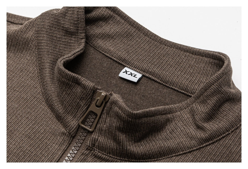 Close-up of a brown textured jacket collar, zipper, and inner size label marked XXL.
