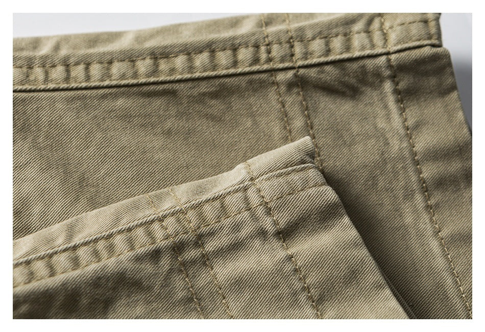 Close-up of khaki shorts showing stitched hems and overlapping fabric panels.