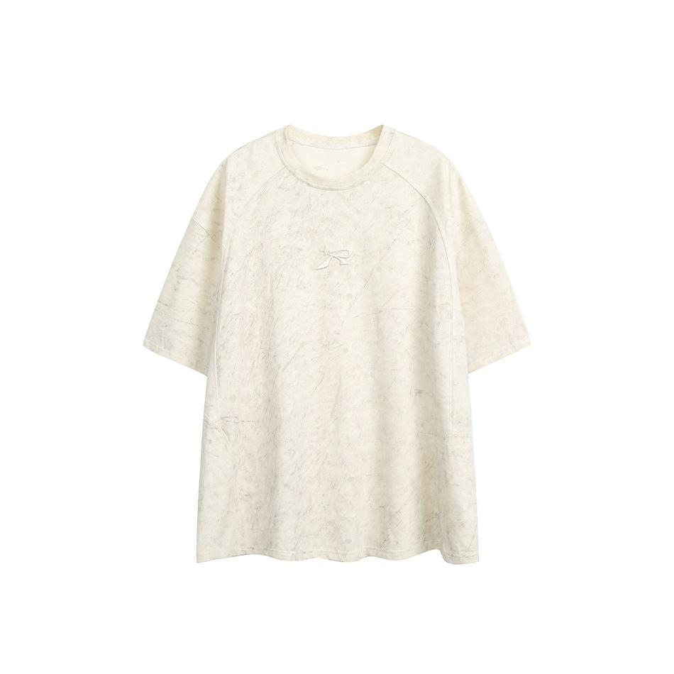 Beige short-sleeve crew-neck T-shirt with mottled texture and small embossed logo at center chest, flat front view