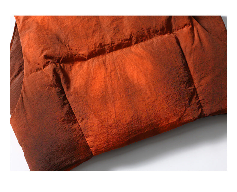 Close-up of rust-orange garment fabric showing overlapping panels and seams.