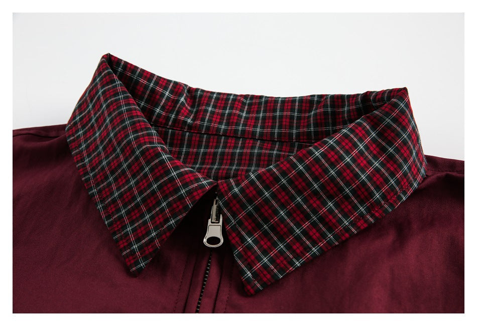 Close-up of the jacket's red-and-black plaid collar, burgundy body, and silver zipper pull.