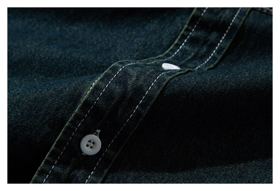 Close-up of dark indigo-green fabric and a stitched button placket with white buttons.