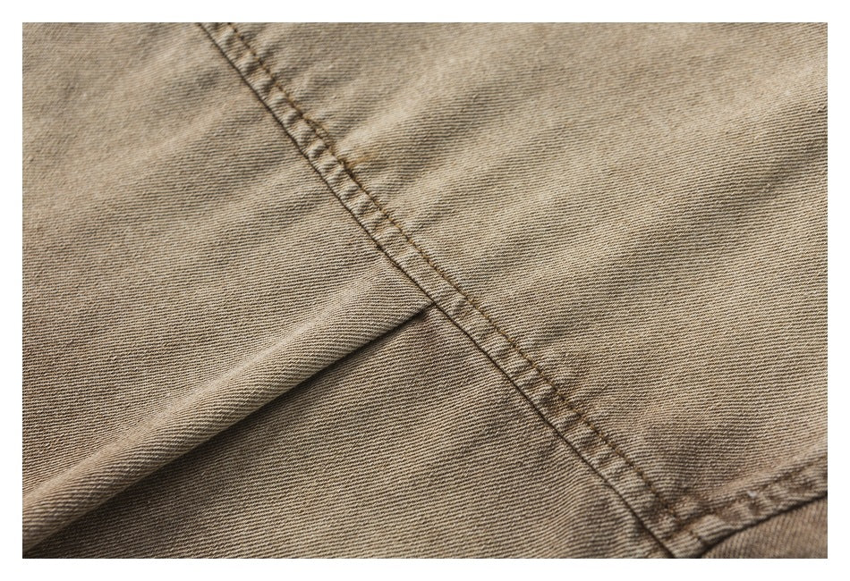 Close-up of double stitching and a folded seam on brown twill fabric.