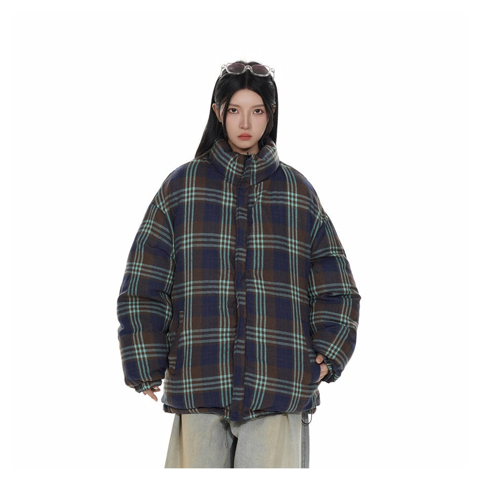 Front view of a model wearing a brown, navy and teal plaid puffer jacket with a high collar.