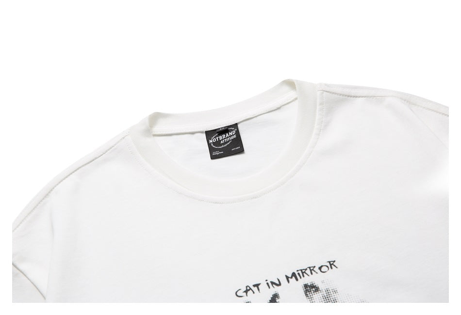 Close-up of the crew neckline and shoulder seams of a white T-shirt, with a black neck label.