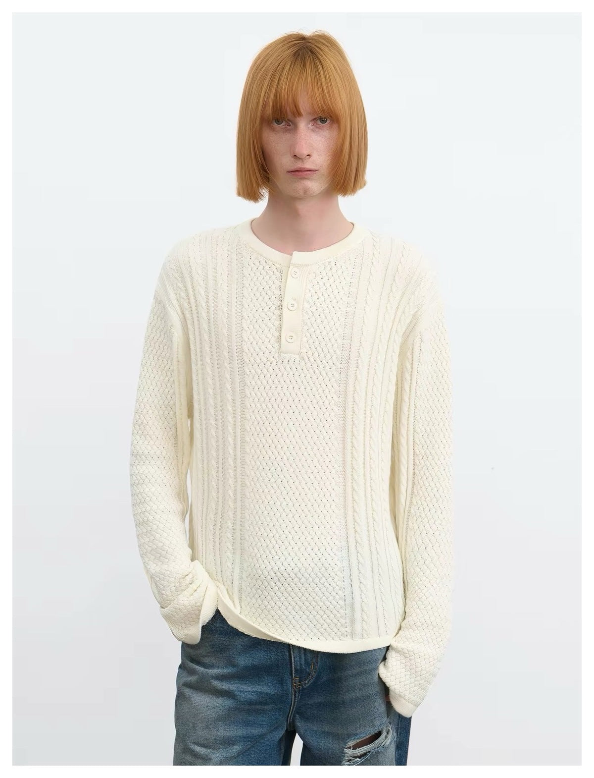 Front view of a model wearing an ivory textured knit pullover with a three-button placket.