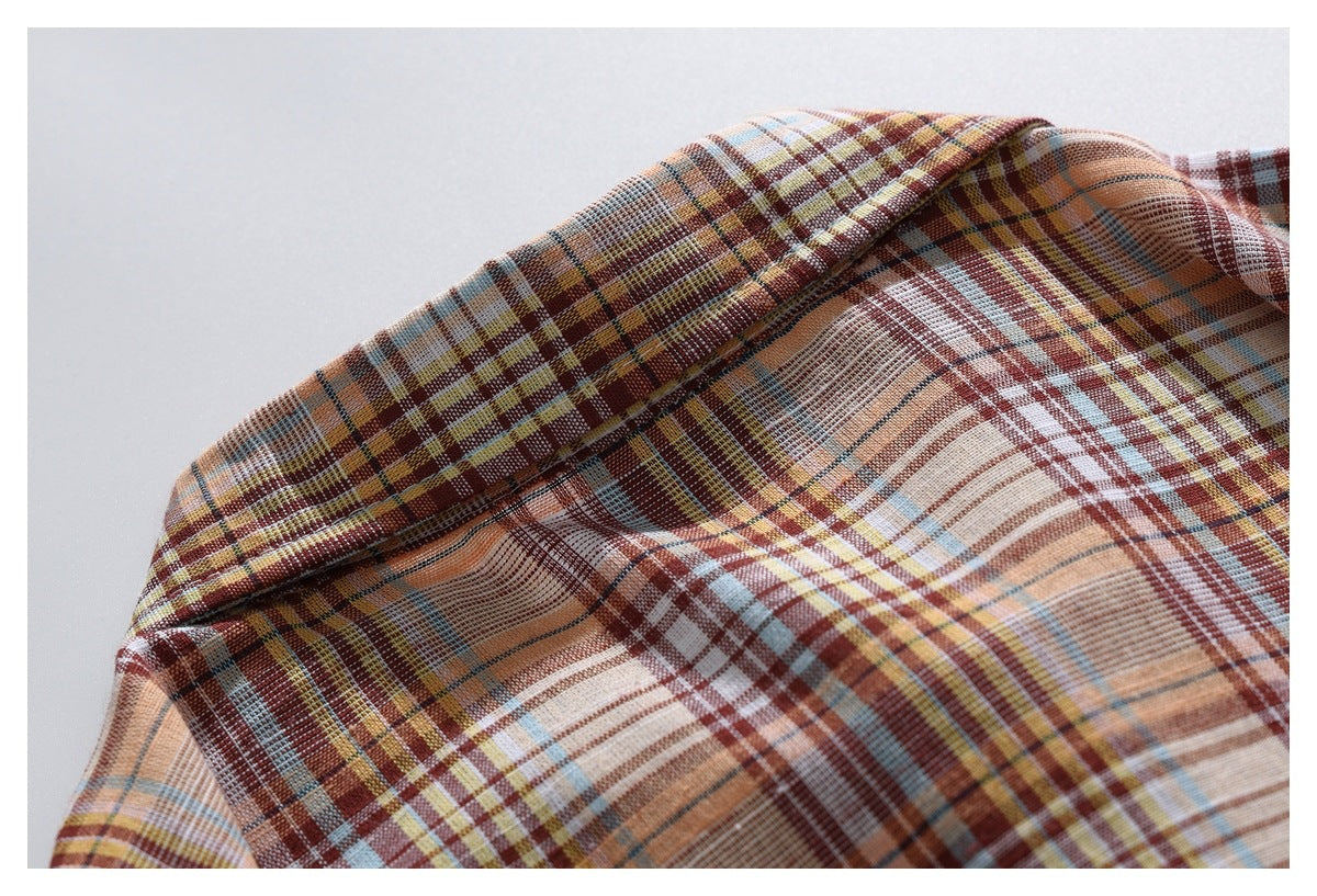 Close-up of a rust, cream, mustard, and blue plaid garment collar and fabric.