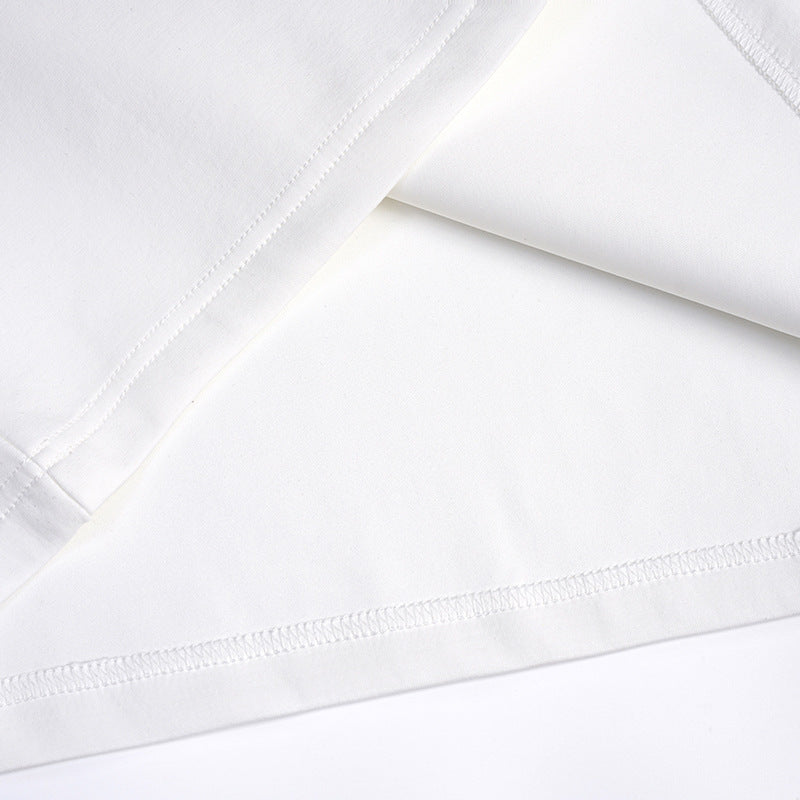 Close-up of the white T-shirt's folded fabric and stitched hem.