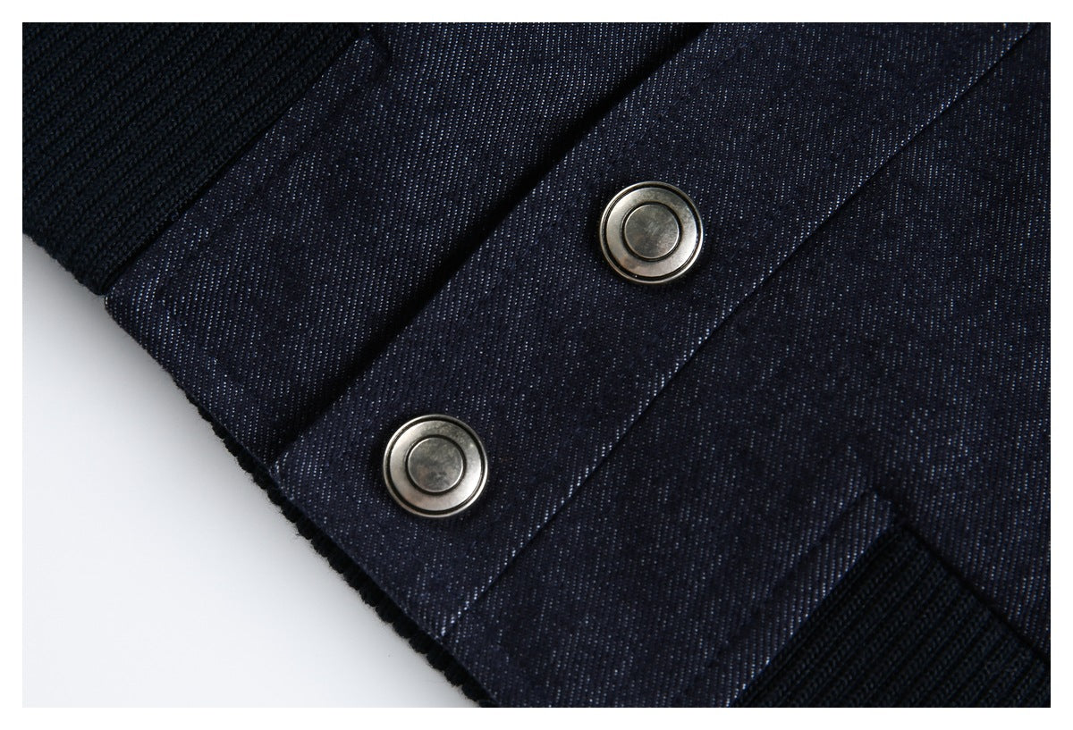 Close-up of a dark navy garment's snap-button placket and black ribbed trim.