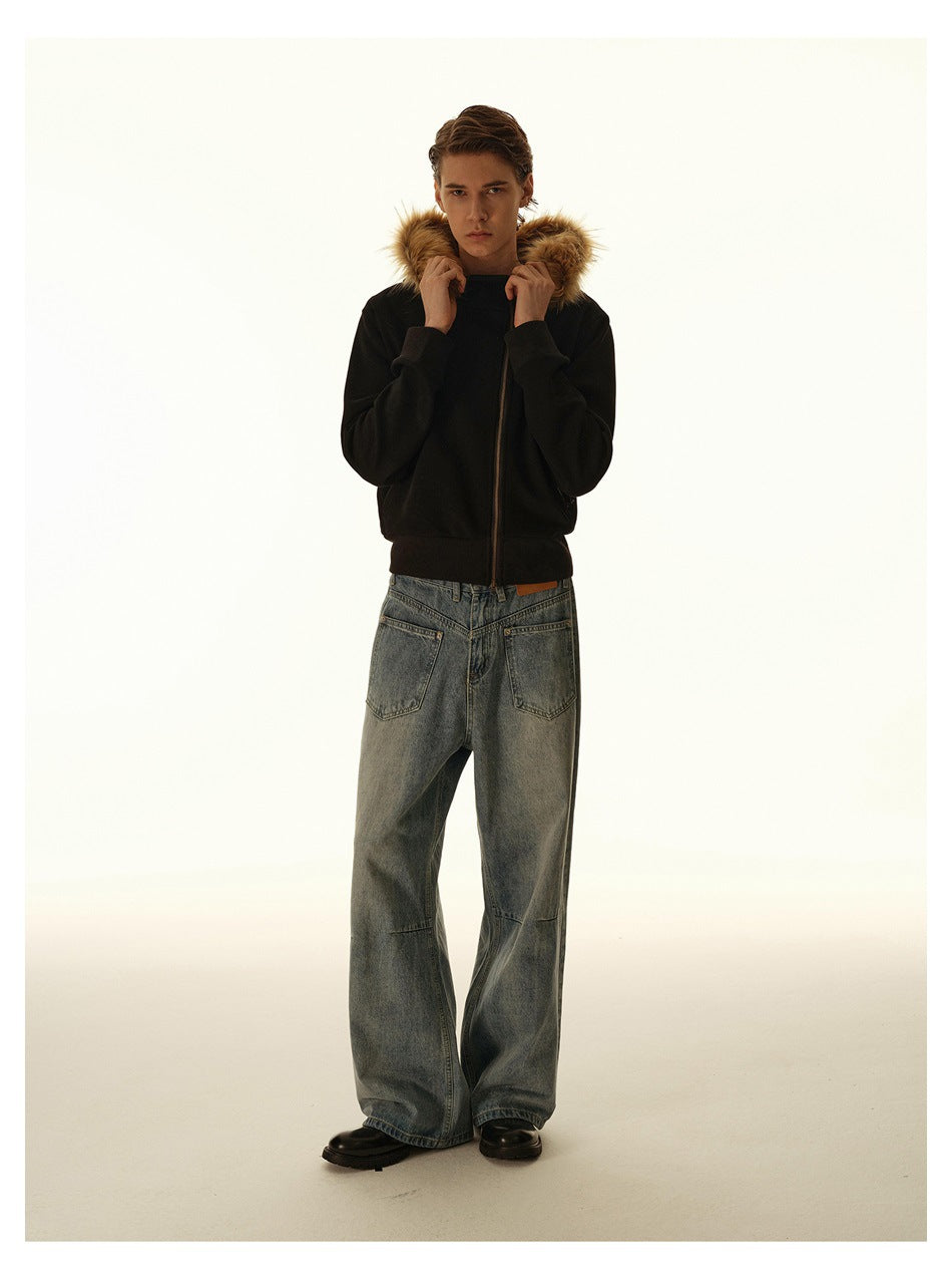 Full-length man wearing a black jacket with a tan fur-trimmed hood and loose, faded gray jeans.