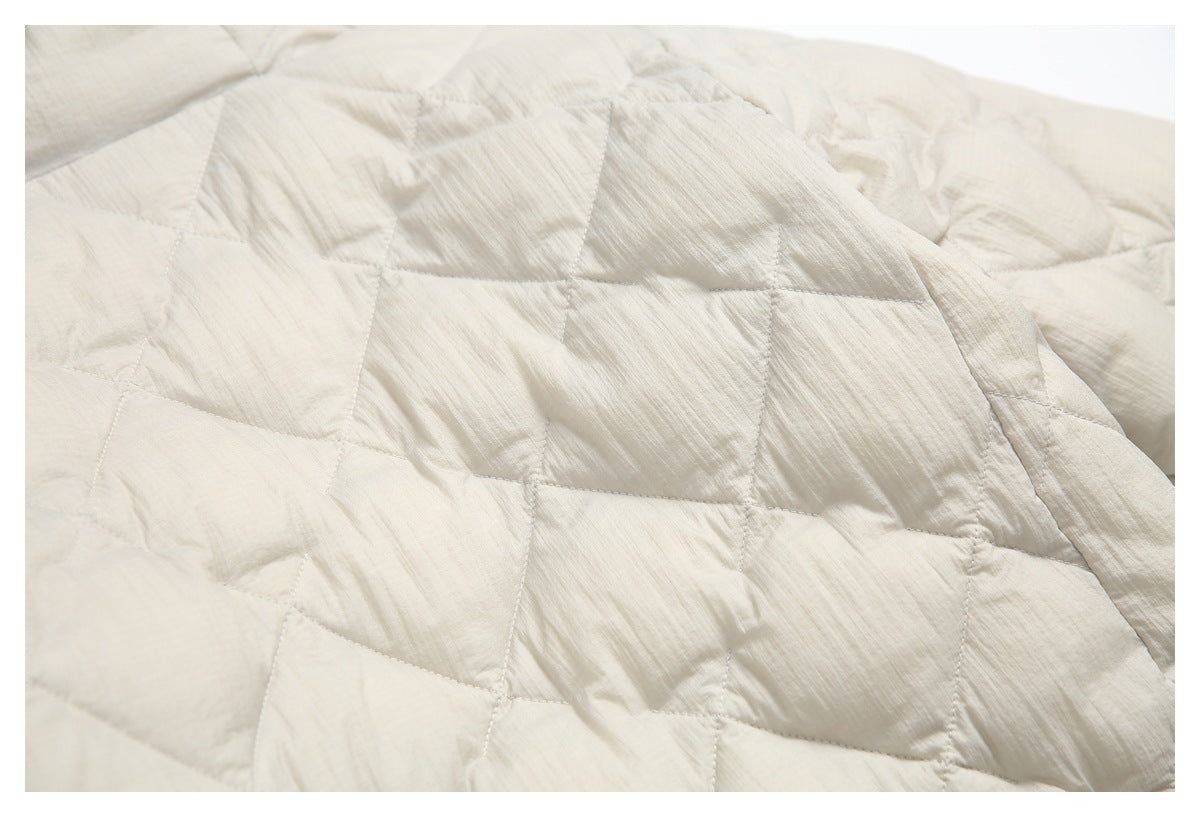 Close-up of the cream jacket's quilted fabric and stitched geometric panels.