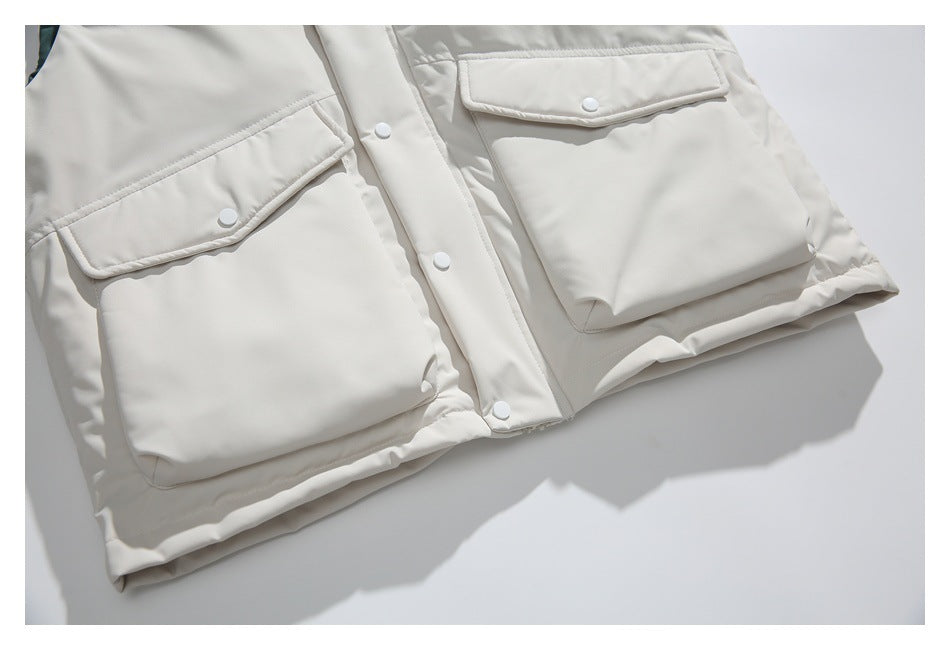 Cropped front of an ivory jacket showing two large flap pockets and a snap-button placket.