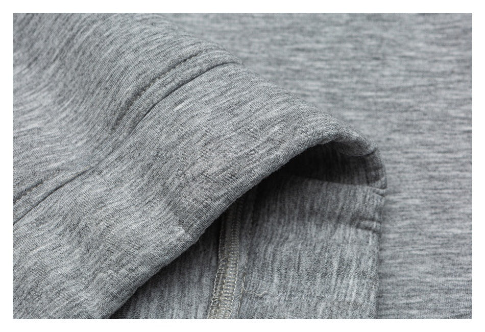 Close-up of a stitched garment edge and seam in heather gray knit fabric.