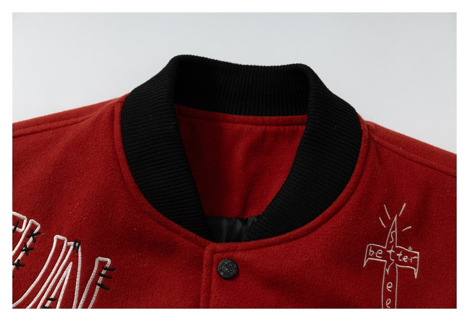 Close-up of the jacket's black ribbed collar, red neckline, snap button, and embroidered lettering.