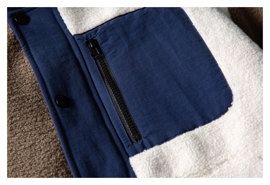 Close-up of a black zip pocket and snap placket on the navy-trimmed cream and brown fleece jacket.