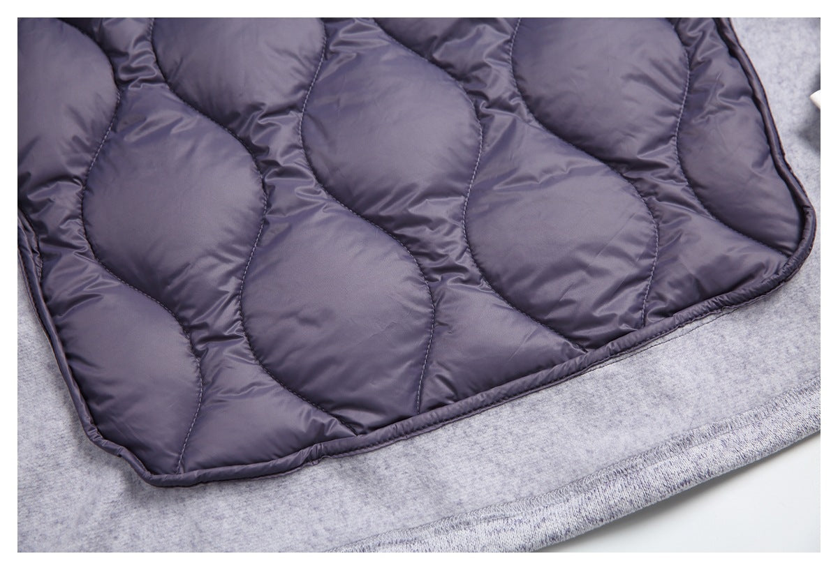 Close-up of the dark plum-gray quilted lining and its stitched panels against the light gray heather jacket.