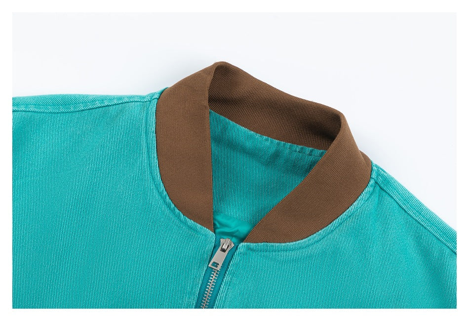 Close-up of the jacket's brown ribbed collar and turquoise fabric around the front zipper.