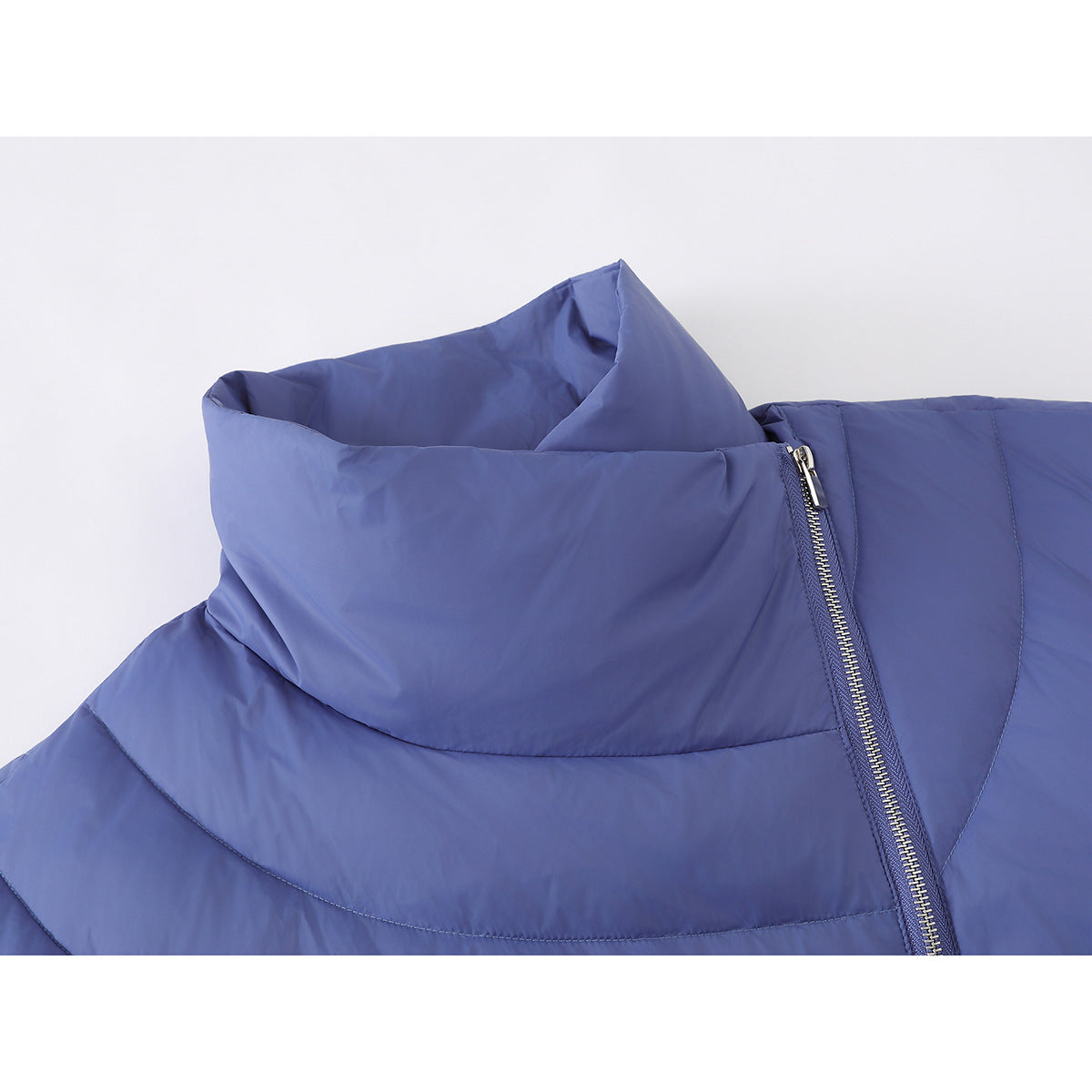 Close-up of a blue padded jacket's tall collar, curved stitching, and silver front zipper.