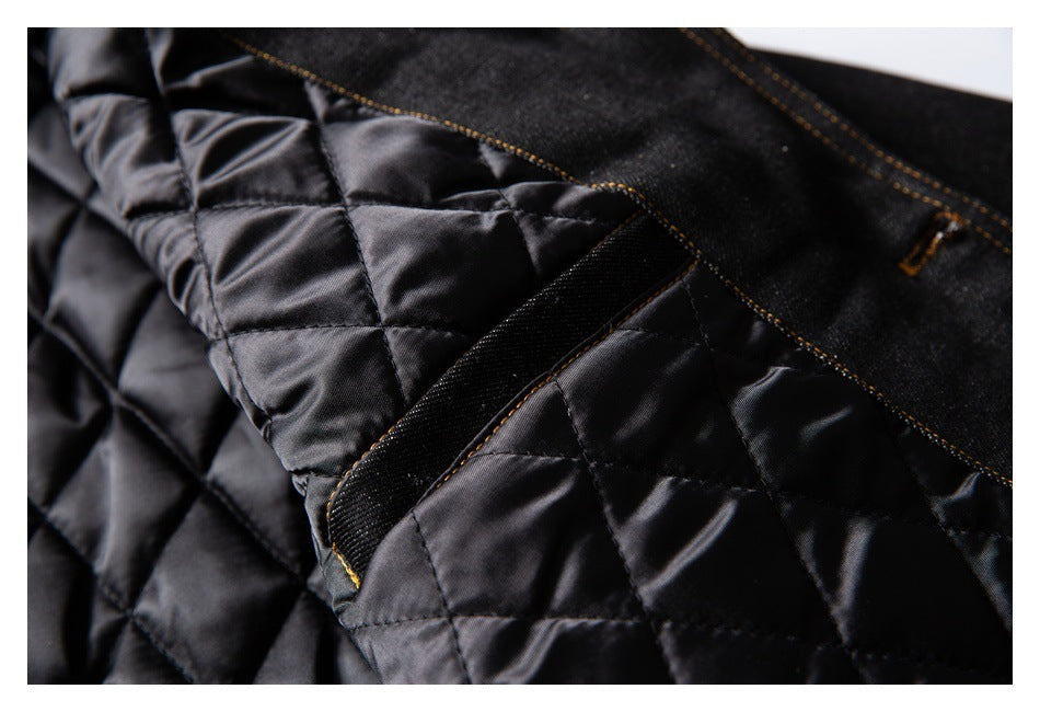 Close-up of black diamond-quilted jacket lining beside a black denim panel and stitched strap.