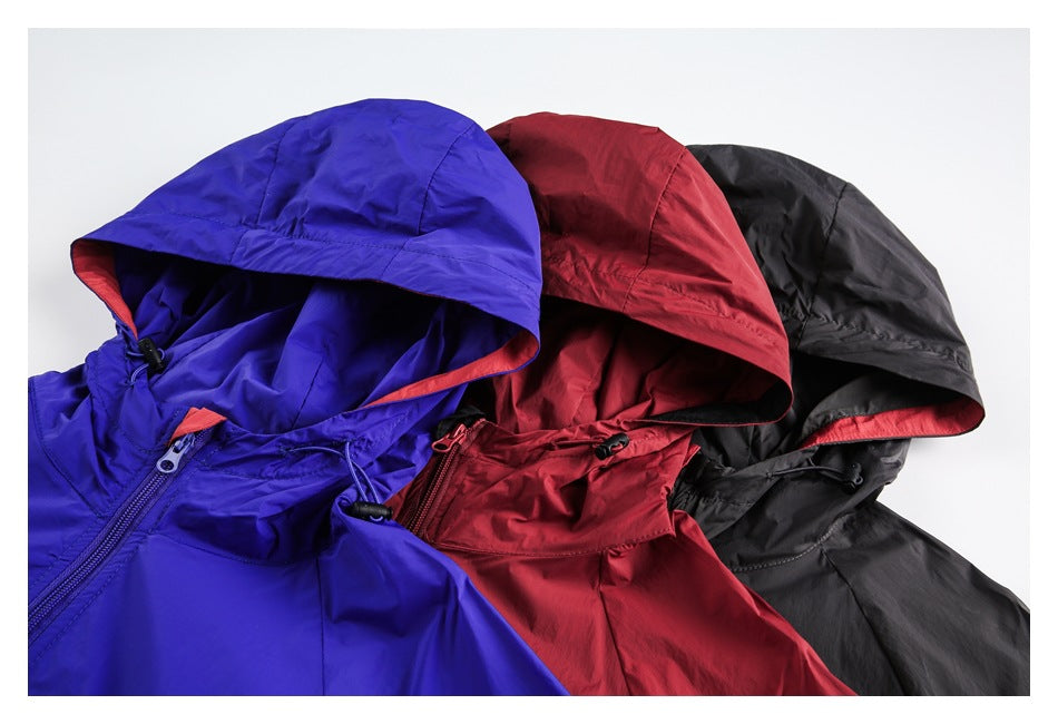 Three hooded jackets in blue, red, and black, arranged together to show their hoods and front zippers.