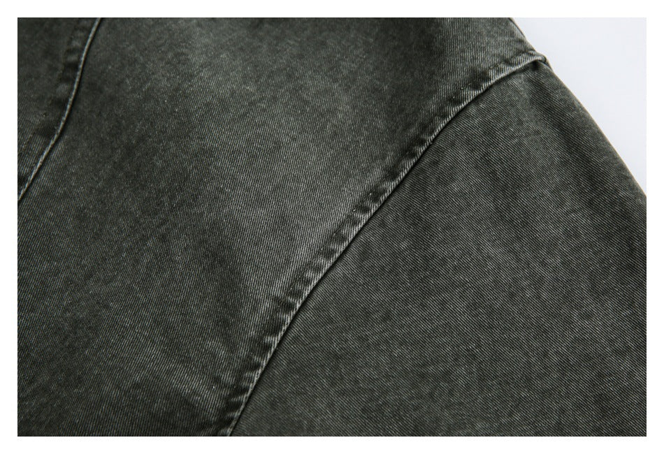 Close-up of a dark charcoal jacket sleeve and curved shoulder seam.