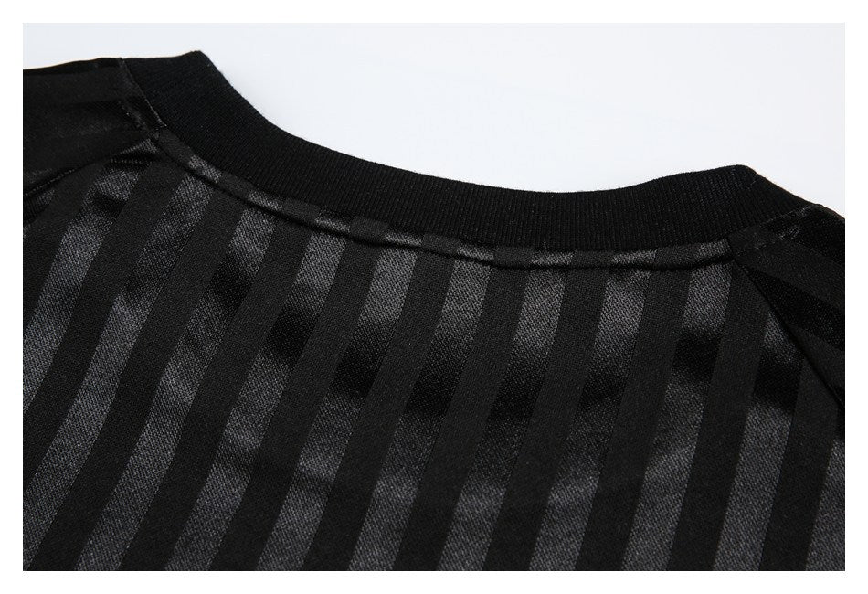 Close-up of a black ribbed crew neckline with vertical tonal stripes.