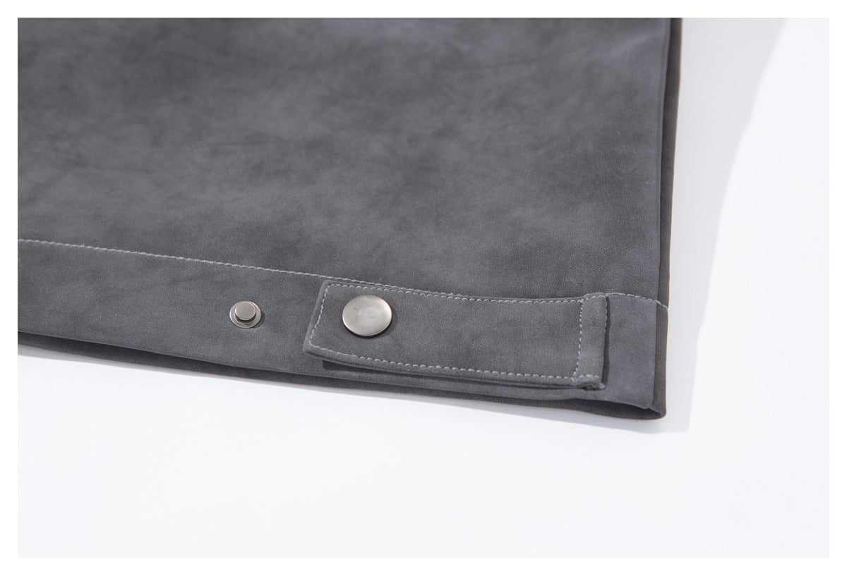 Close-up of the jacket hem with an adjustable snap-button tab and metal fastener.